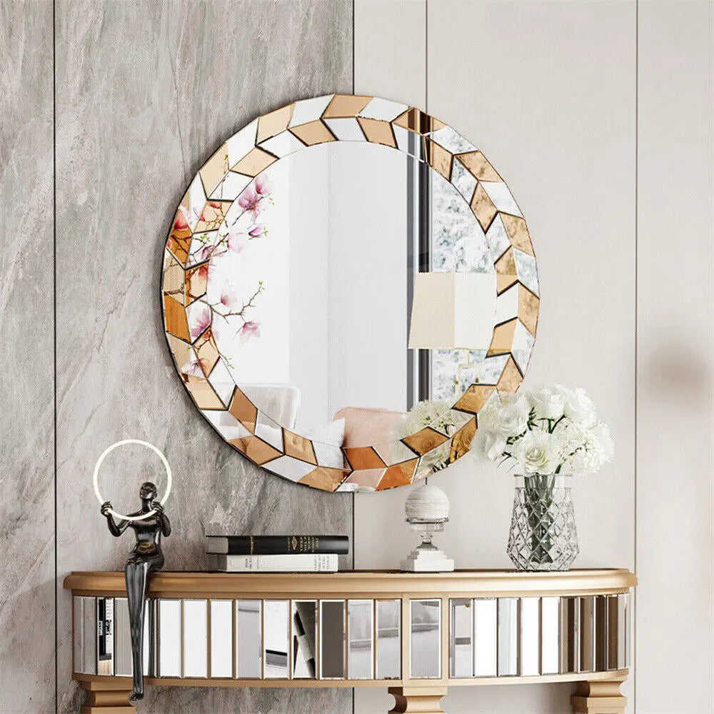 Un miroir rond décoratif encadré de mosaïque dorée et de fleurs de cerisier, placé sur une console en bois, avec un vase de fleurs blanches, des livres et une figurine décorative.