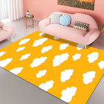 Tapis coloré avec motif de nuages blancs sur un fond jaune vif dans un salon cosy et lumineux.