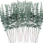 bouquet artificiel feuilles vertes naturel minimaliste ruban blanc vase blanc tapis beige ornement extérieur