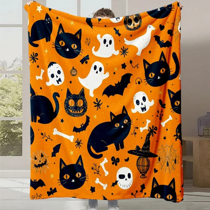 Couverture Halloween avec chats noirs, fantômes blancs et autres motifs effrayants sur un fond orange.