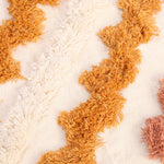 Un tapis doux et moelleux aux couleurs naturelles texturées, créant une atmosphère chaleureuse et accueillante.