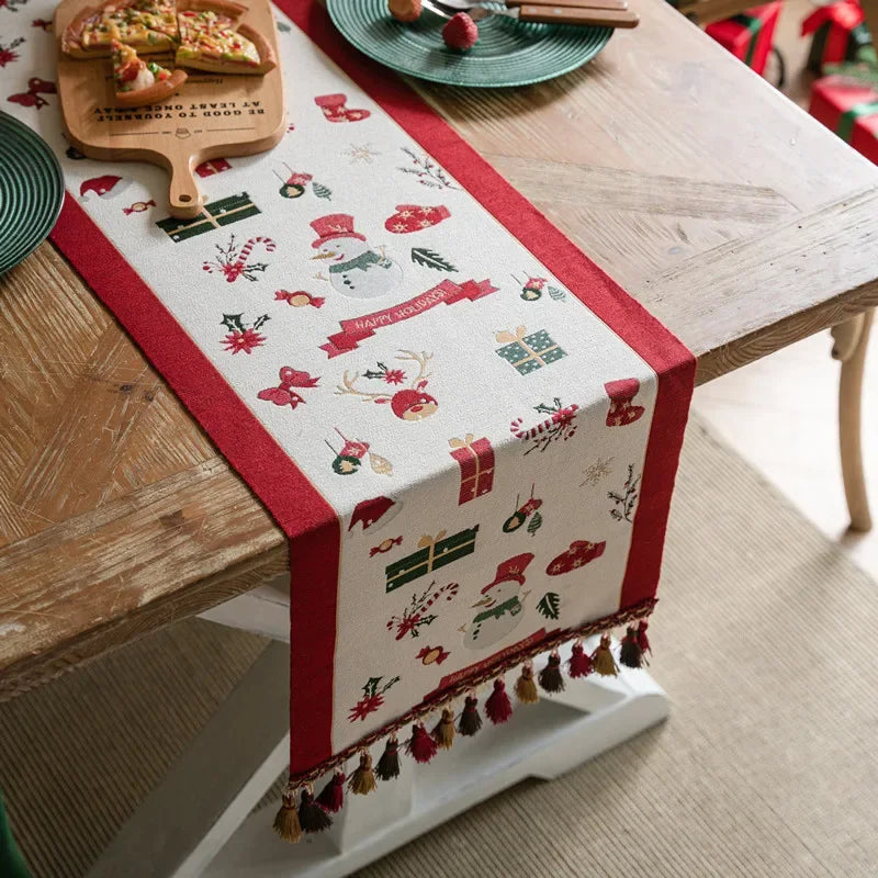 Une élégante nappe de table décorée de motifs de Noël festifs, comme des flocons de neige, des bonhommes de neige et des cadeaux, sur une table en bois rustique avec des accessoires de table assortis.