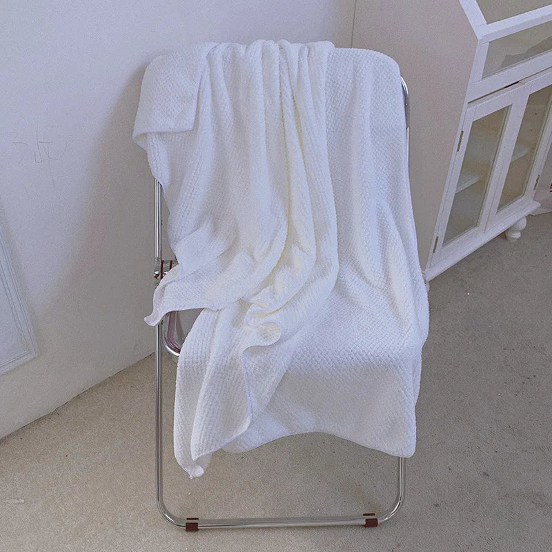 Une serviette blanche propre et moelleuse est posée sur un support en métal.