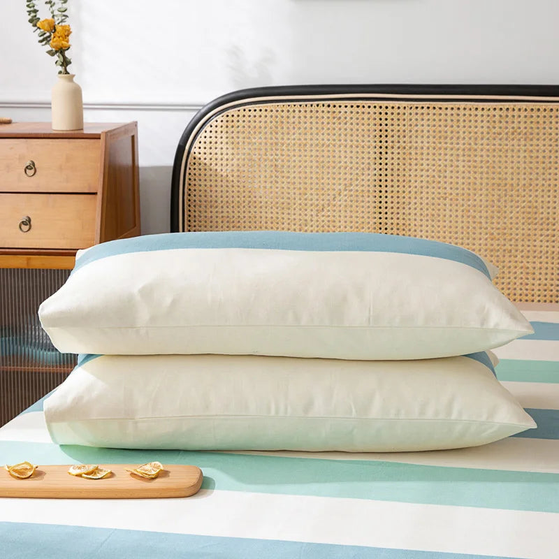 Deux oreillers moelleux et confortables posés sur un lit avec un fond de chambre vintage élégant et une touche de nature représentée par les fleurs.