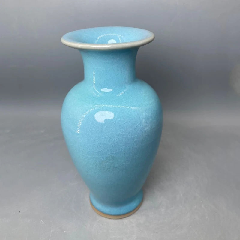 Vase en céramique de couleur turquoise avec une surface lisse et brillante.