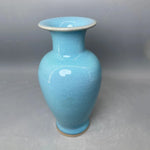 Vase en céramique de couleur turquoise avec une surface lisse et brillante.