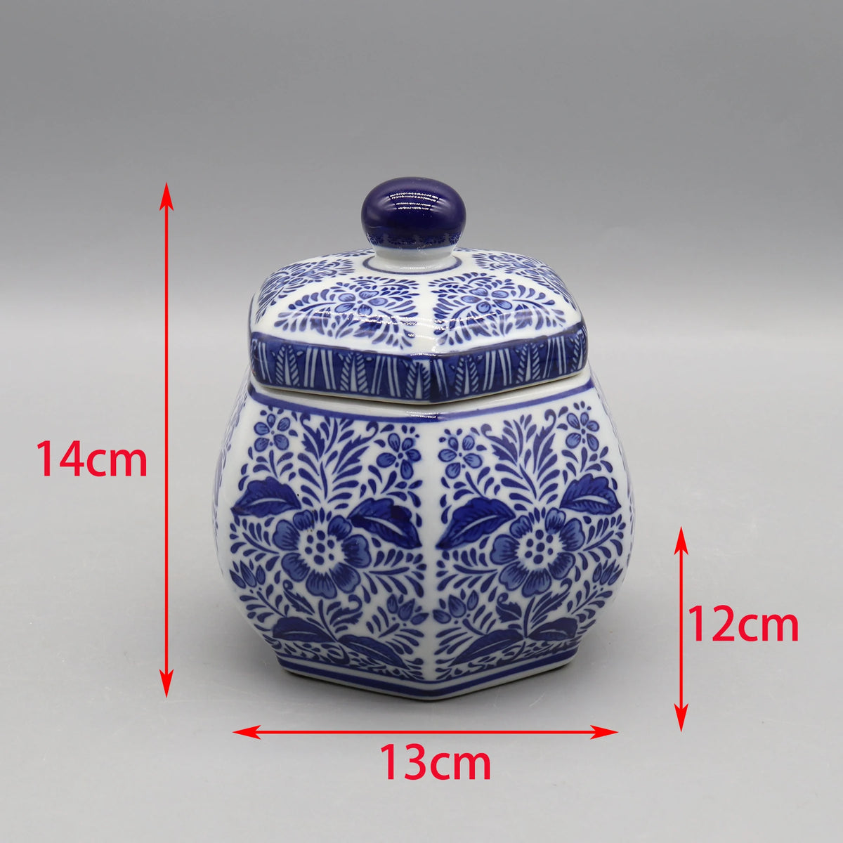 Pot décoratif en céramique bleu et blanc avec un motif floral, mesurant 14 cm de hauteur, 13 cm de largeur et 12 cm de profondeur.