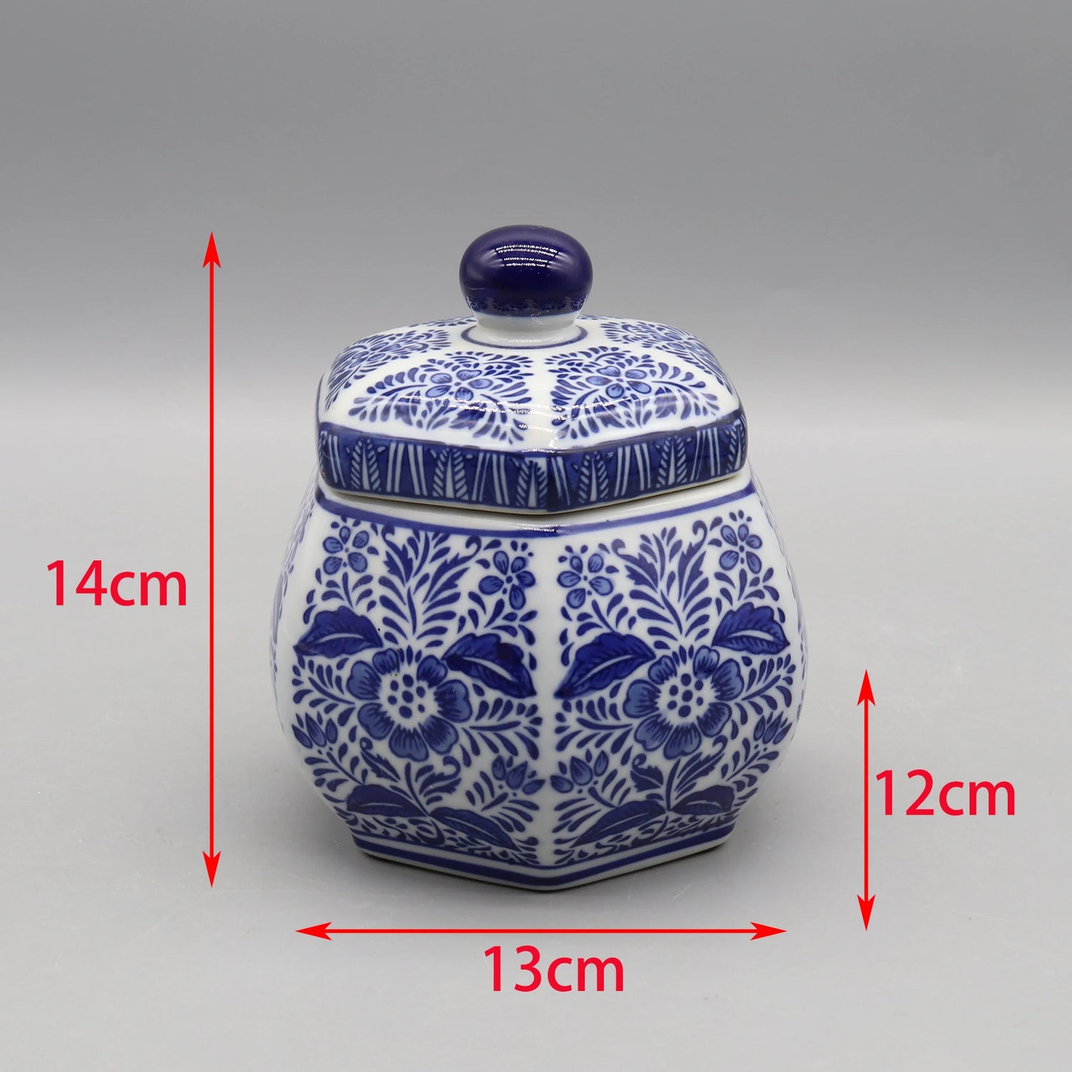 Pot décoratif en céramique bleu et blanc avec un motif floral, mesurant 14 cm de hauteur, 13 cm de largeur et 12 cm de profondeur.