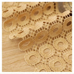 Dentelle beige ajourée avec motif circulaire, idéale pour décoration de vêtements, projets de couture et accessoires mode, apportant une touche élégante et sophistiquée. Parfait pour embellir vos créations textiles et ajouter une note raffinée à tout projet créatif.