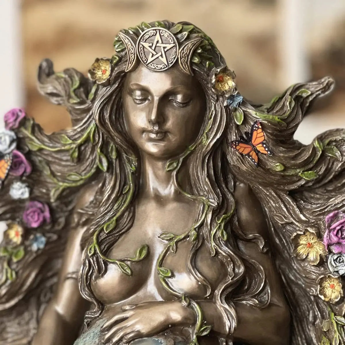 statue féminine bronze feuilles roses papillon terre étoile nature mythologie