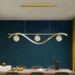 suspension lumineuse moderne or noir courbes élégantes contemporain chaînes suspendues trois sphères luminescentes barre