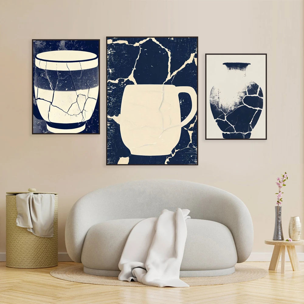 Des motifs abstraits de couleur bleu et blanc sur des toiles encadrées accrochées au mur derrière un canapé blanc.