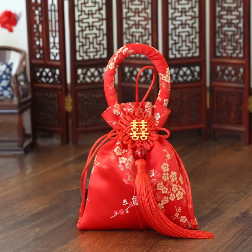 sac main traditionnel rouge broderie dorée motifs floraux poignée circulaire pompon décoration festiveoccasionnels