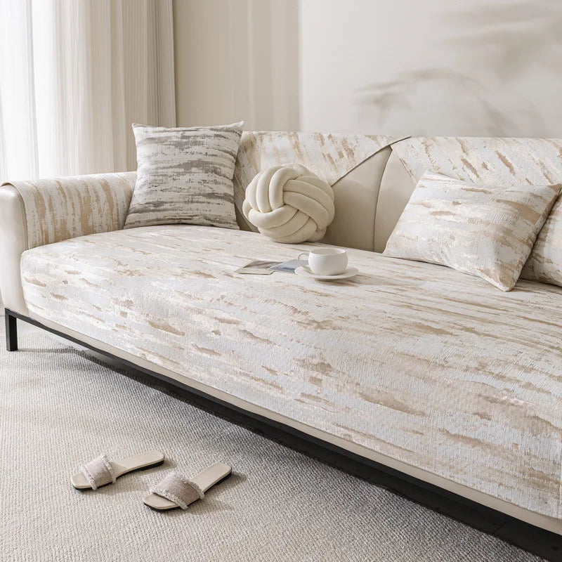 Un canapé confortable et élégant avec des coussins décoratifs dans un environnement lumineux et épuré.