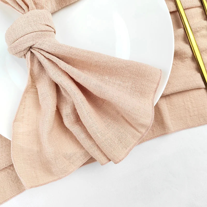 Une écharpe en soie beige avec un nœud élégant, sur fond blanc.