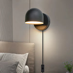 Applique murale LED blanche éclairant un chevet de chambre