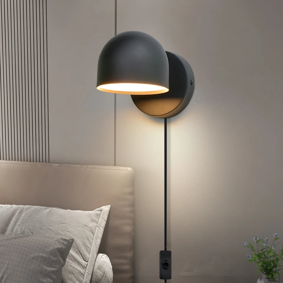 Applique murale LED blanche éclairant un chevet de chambre