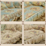 Couvre-lit et taies d'oreiller en tissu fleuri à motifs de style baroque dans des tons de bleu et de beige, avec des volants et des bordures décoratives.