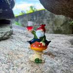 statue gnome assis champignon rouge vêtement vert pantalon bleu barbe blanche verre vin opaque