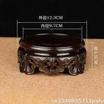 support circulaire bois sculpté artisanal traditionnel marron foncé détails complexes vase plantes décoration maison