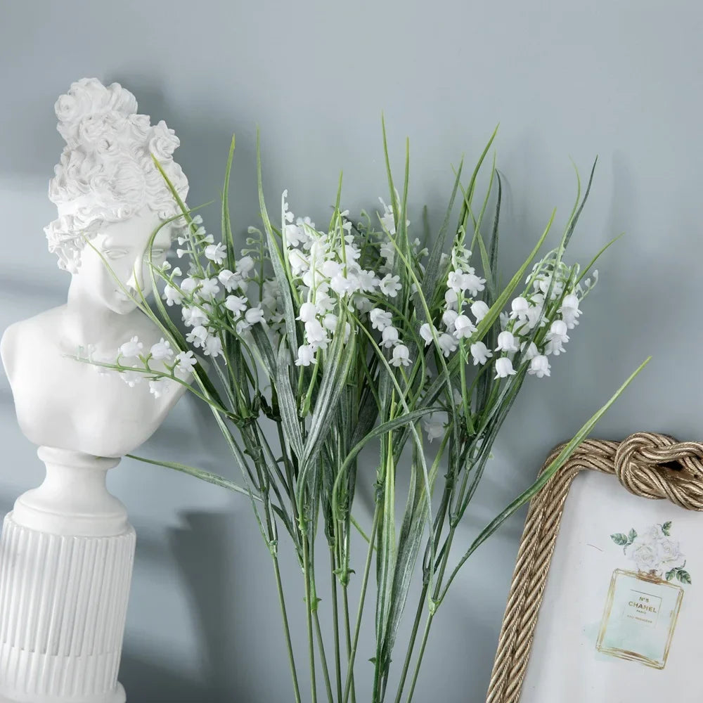 décoration intérieure artificielle fleurs blanches feuilles vertes vase gris translucide statuettes blanches