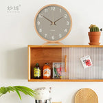horloge moderne bois naturel cadran blanc chiffres noirs fond violet gris