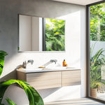 Une salle de bain moderne avec un meuble double lavabo blanc et un miroir encadré, reflétant les feuilles vertes luxuriantes de la végétation à l'extérieur.