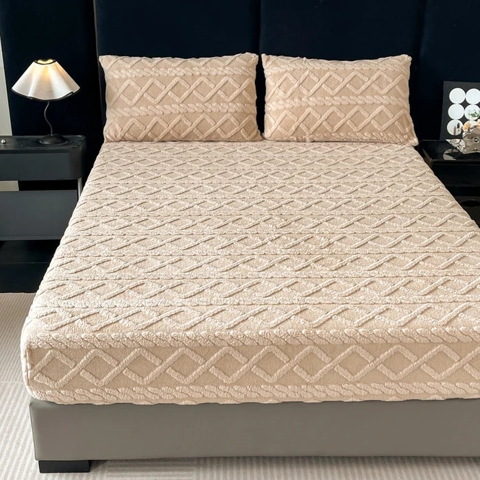 Lit double avec couvre-lit matelassé beige orné de motifs en diagonale et de deux oreillers assortis.