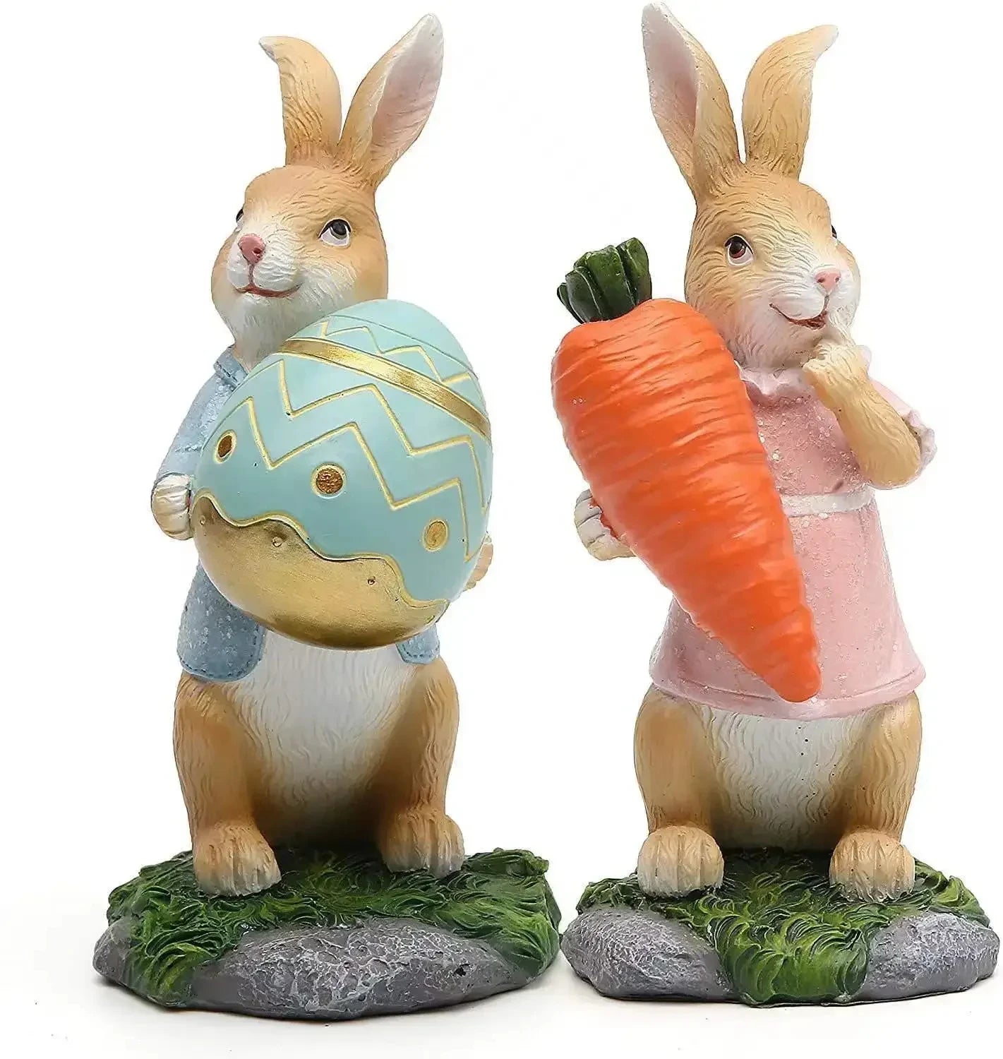 Deux figurines de lapins décoratifs avec des accessoires de Pâques, l'un tenant un œuf de Pâques décoré et l'autre une grosse carotte, posés sur un socle en forme de gazon.