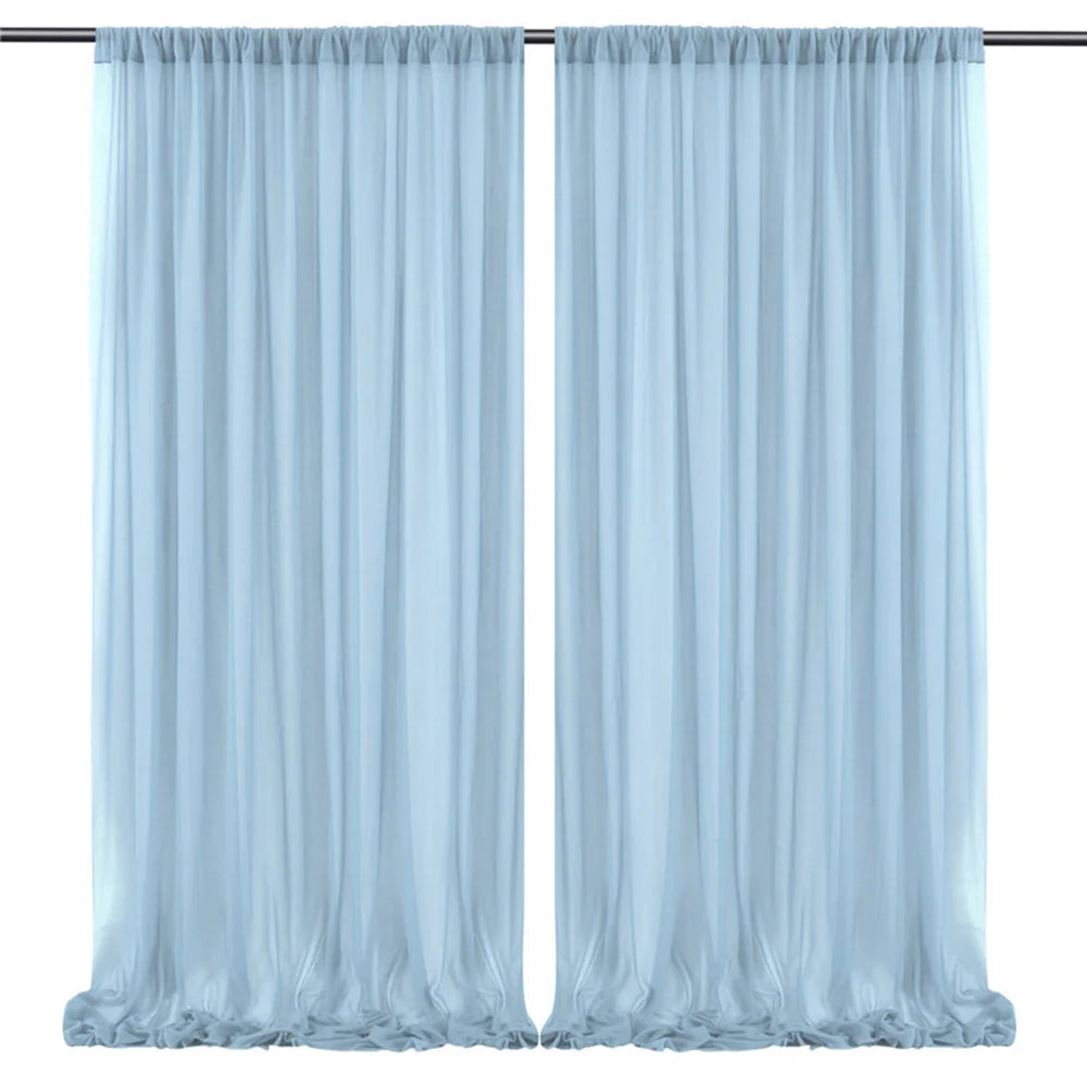 Des rideaux en voile bleu pastel, suspendus à une tringle, ornent la fenêtre de manière élégante et apaisante.