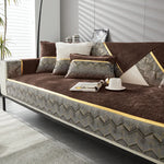 Canapé en textile marron et motifs géométriques, avec coussins décoratifs et une tasse posée à côté, dans un intérieur lumineux avec palmiers.