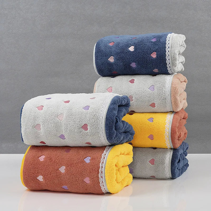 Une pile de serviettes de bain colorées et à motifs de cœurs.