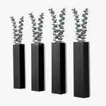 Jardinière murale noire en bois avec plantes vertes dans un salon moderne