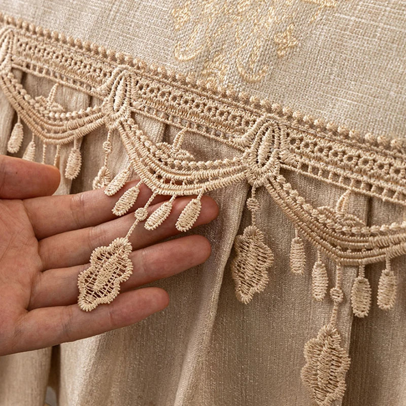 L'image montre un détail de tissus beige orné de motifs de dentelle aux allures délicates et élégantes.