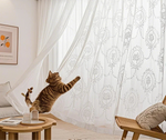Voilage blanc esprit bord de mer avec motif floral et chat en mouvement dans un salon lumineux
