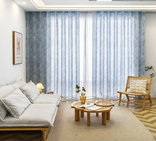Voilage grande largeur à ruflette bleu clair installé dans un salon lumineux au style scandinave.