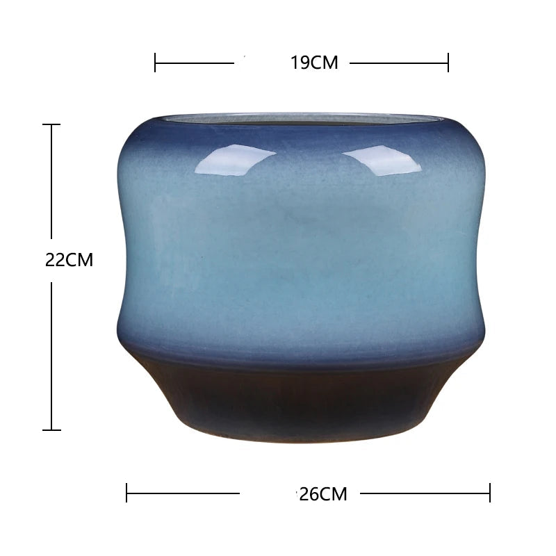 Bol en céramique de forme arrondie, de couleur bleu nuageux avec des accents sombres, avec des dimensions d'environ 26 cm de largeur et 22 cm de hauteur.