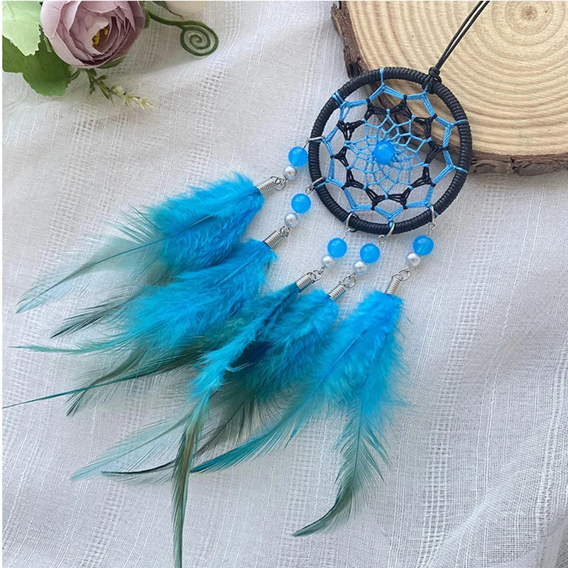 Un attrape-rêves bleu aux plumes turquoise, accrochés à un cercle de fils tressés, créant une décoration aux tons naturels.
