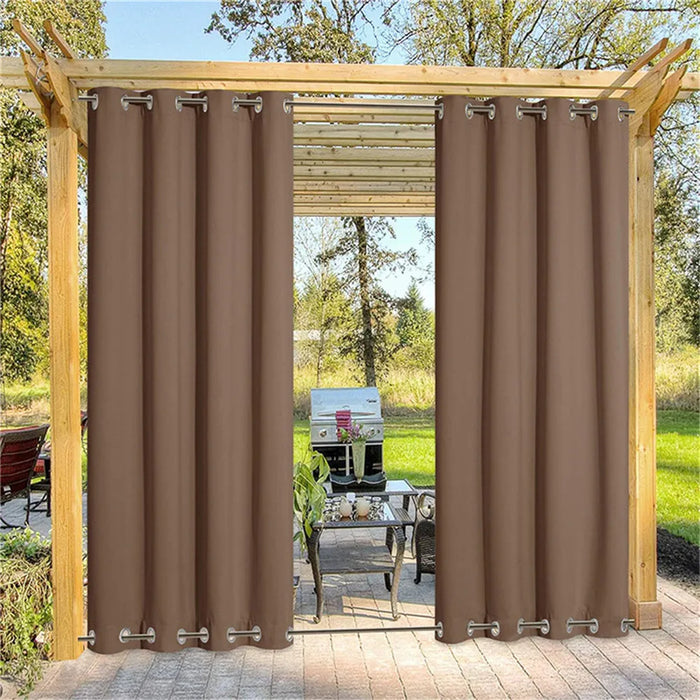 Rideau d'extérieur marron occultant avec œillets, installé sur une pergola en bois, créant un espace ombragé et élégant pour une terrasse ou un jardin.