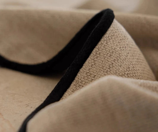 Détail de la texture tissée du voilage épais beige avec bordure noire