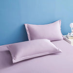 Deux oreillers roses pâle sur un fond bleu clair, offrant un look reposant et relaxant pour une chambre à coucher.