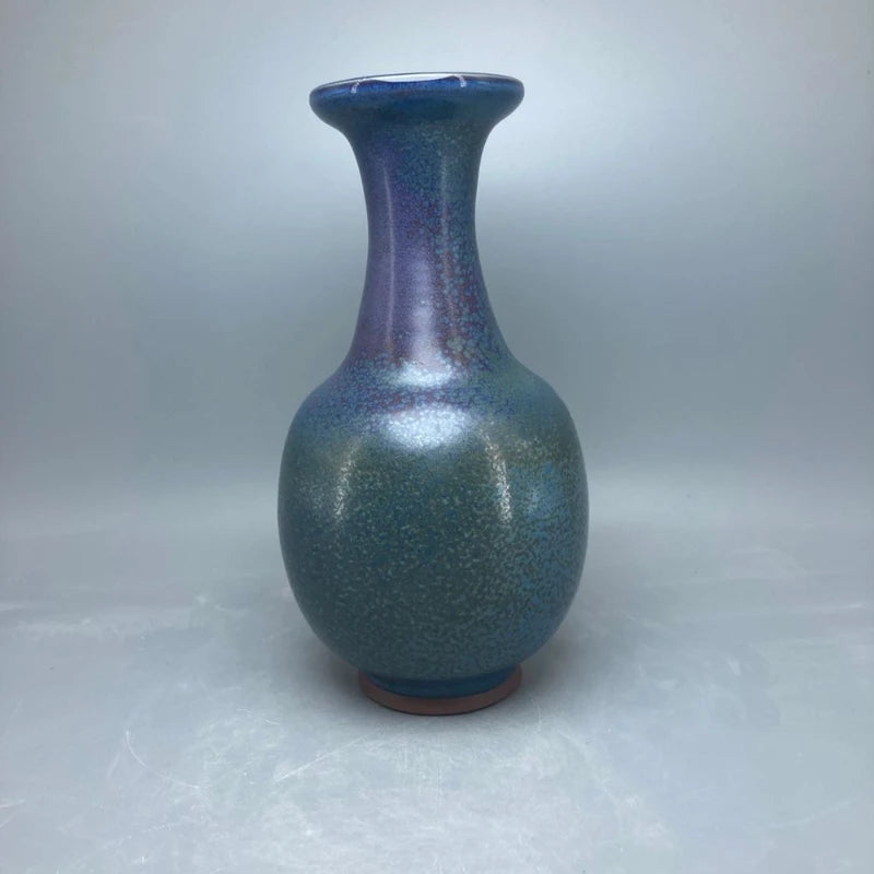 Vase décoratif de forme allongée avec une surface brillante et des tons bleu et vert.
