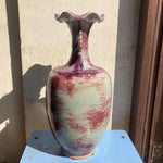Un vase en céramique avec un design iridescent aux couleurs nuancées de violet, de rose et de bleu.