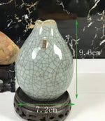 Vase céramique craquelé de forme ovale sur un socle décoratif, mesurant 7,2 cm de largeur et 9,6 cm de hauteur.