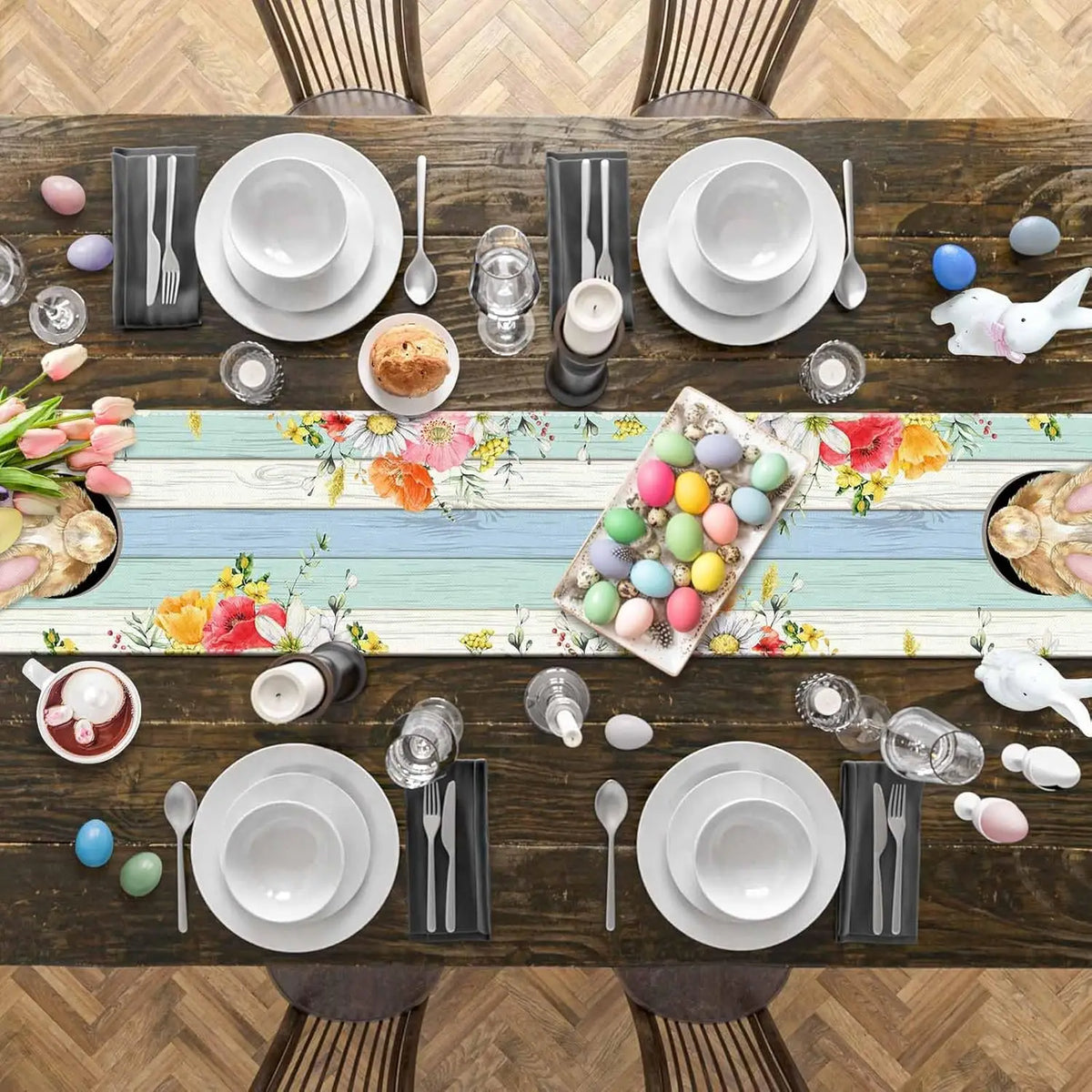 Une table joliment dressée pour un repas de Pâques, avec des assiettes blanches, des couverts en argent, des fleurs colorées et des oeufs peints disposés avec soin.