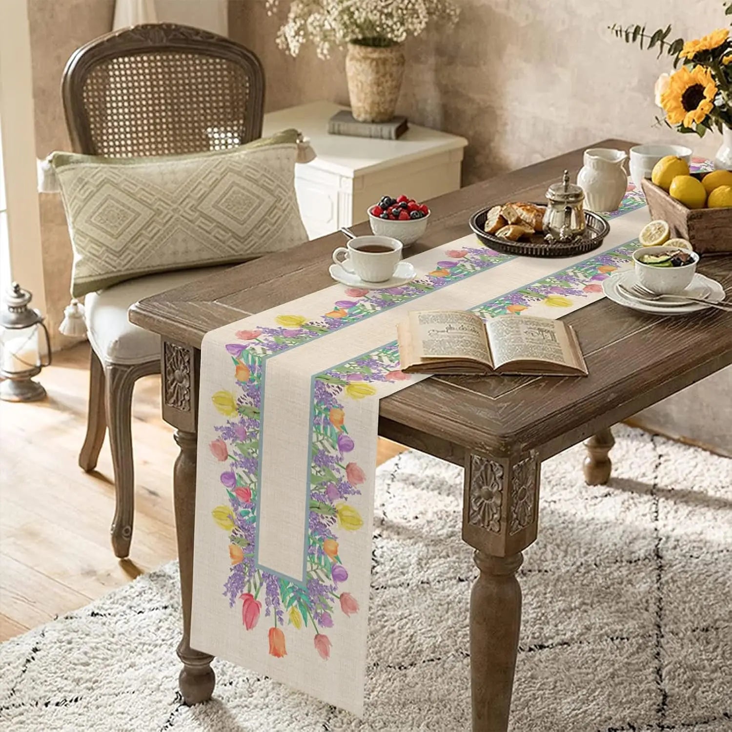 Table de bois rustique avec décorations florales, livre ouvert, tasse de thé et plateau de collations dans une ambiance confortable et accueillante.