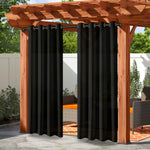 Rideaux extérieurs noirs opaques suspendus à une pergola en bois, créant un espace d’intimité élégant dans un salon de jardin.