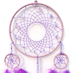 Un attrape-rêves violet orné de perles colorées et de plumes violet pâle, créant une composition délicate et apaisante.