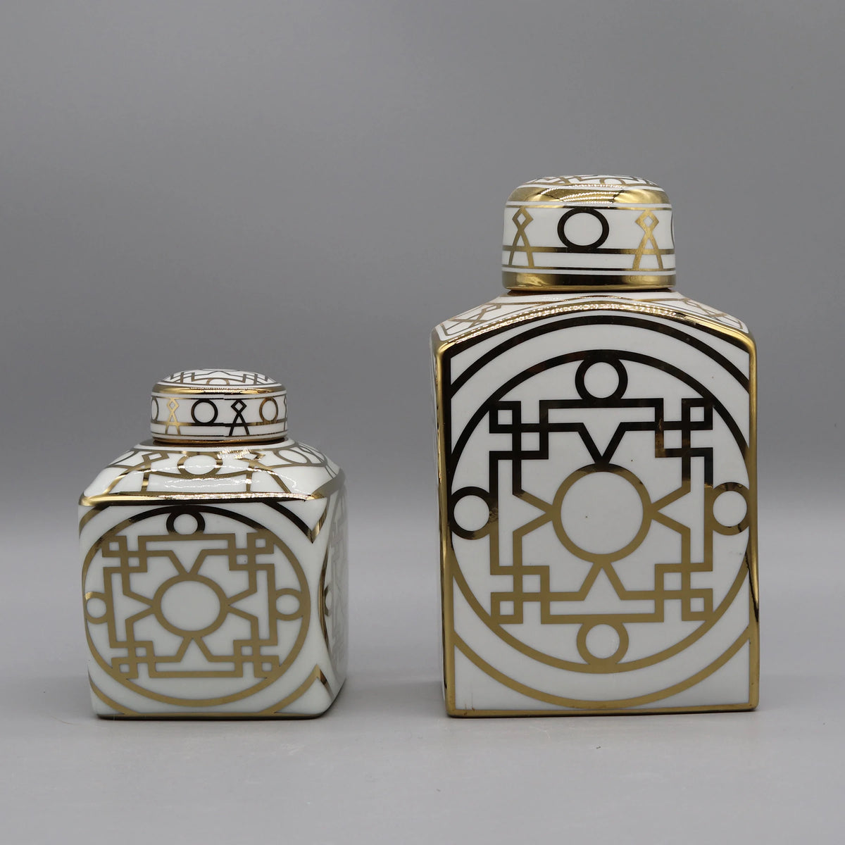 Ces deux récipients décorés de motifs géométriques noirs et or sur un fond blanc apportent une touche de design graphique élégant.