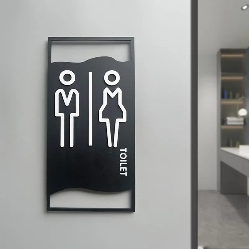 signalisation toilettes moderne symboles homme femme texte TOILET bois brun clair blanc tringle noire